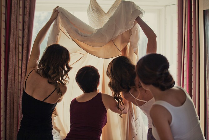 bride and bridesmaids check wedding dress shopping